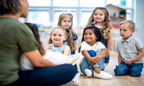 Caregiver engaging in a story time with group of kids