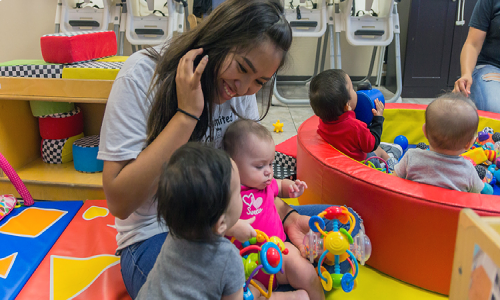 Caregiver holding an infant at NurtureNest