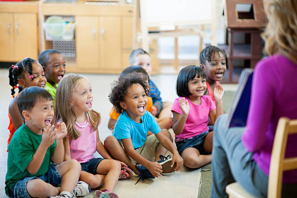 Group of kids happily having a story time with a caregiver